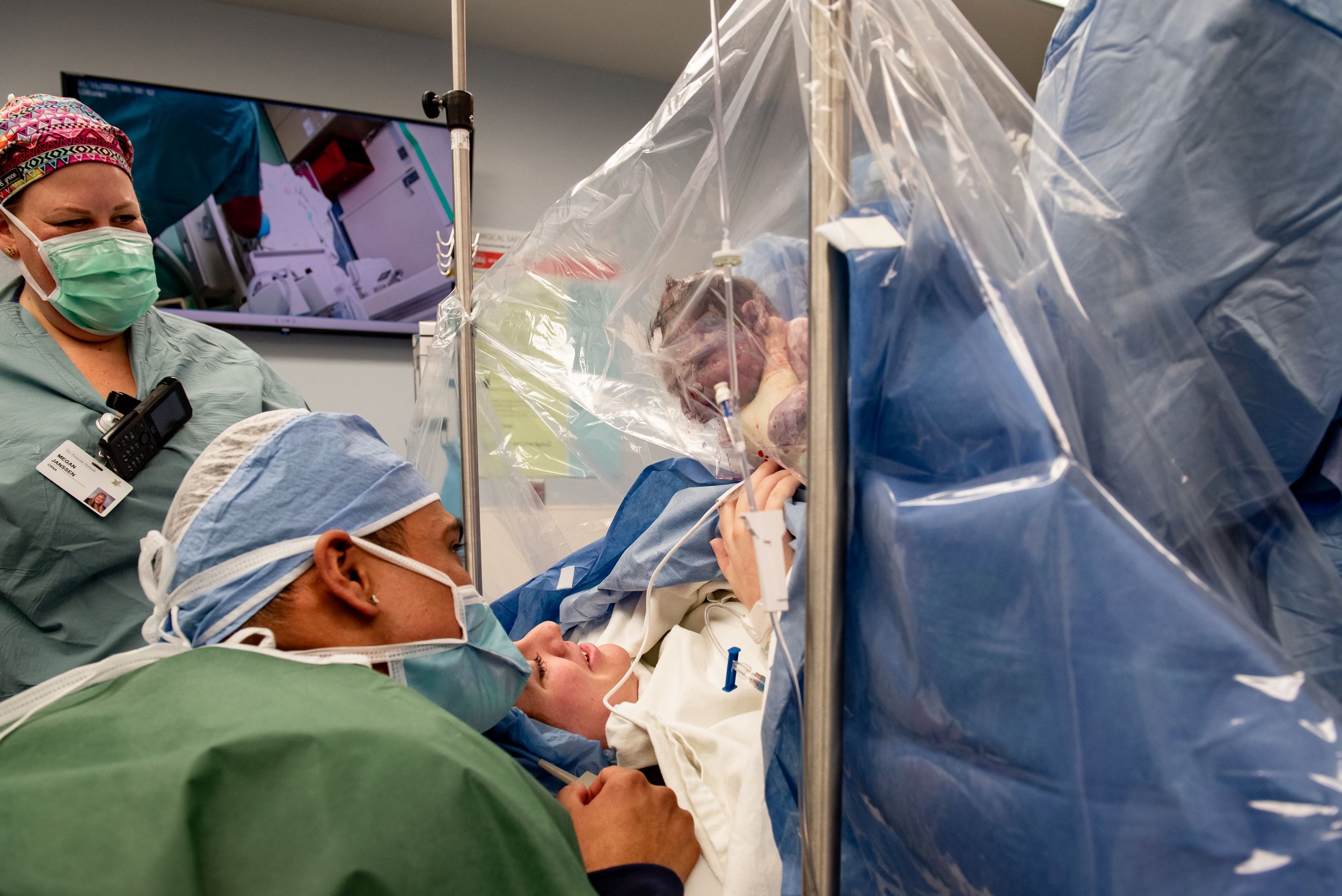 Medical team performs a procedure on a patient in a sterile operating room.