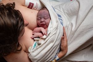 Mother experiencing skin-to-skin contact with her newborn baby after birth.