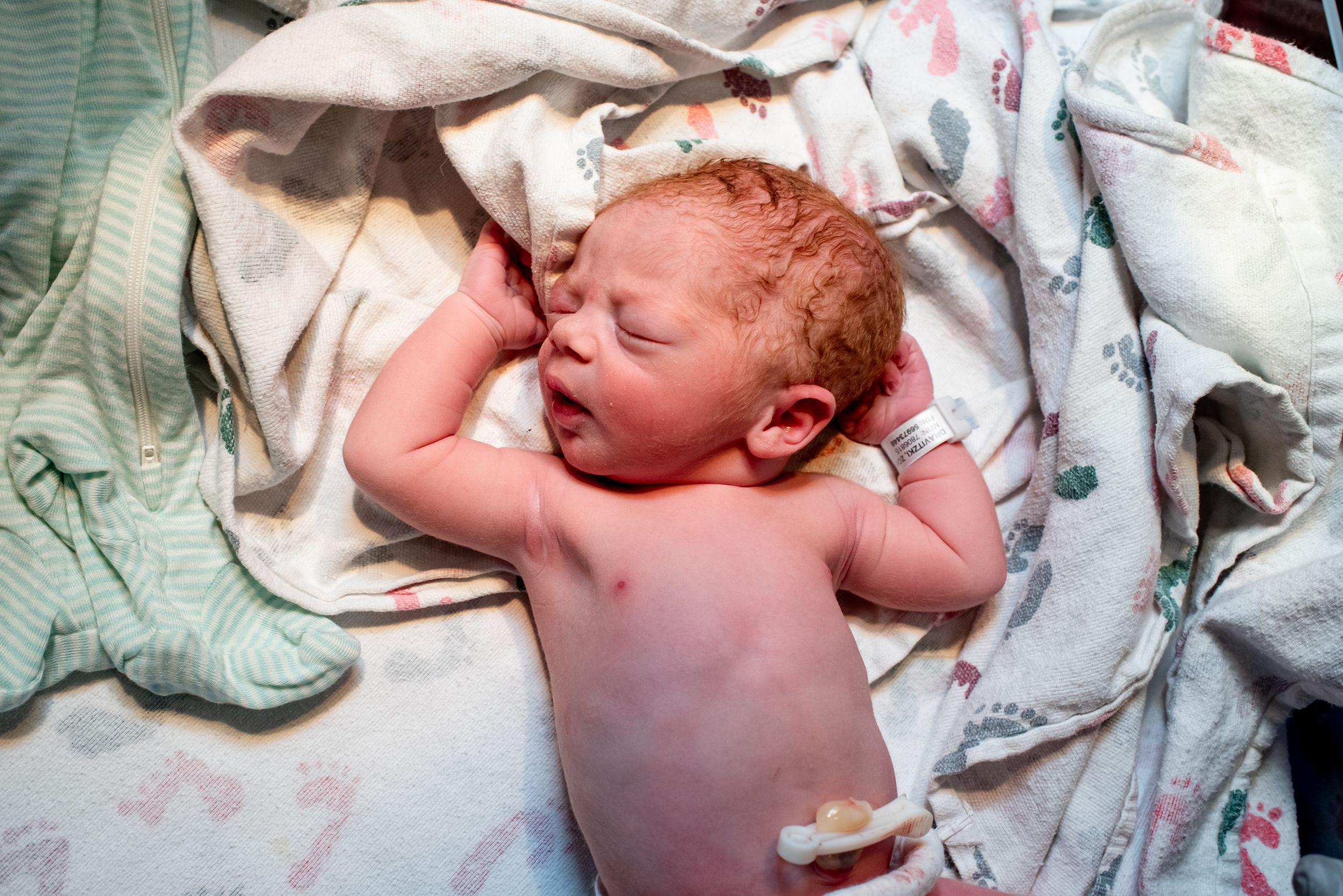 Newborn baby resting peacefully on soft blankets after birth.