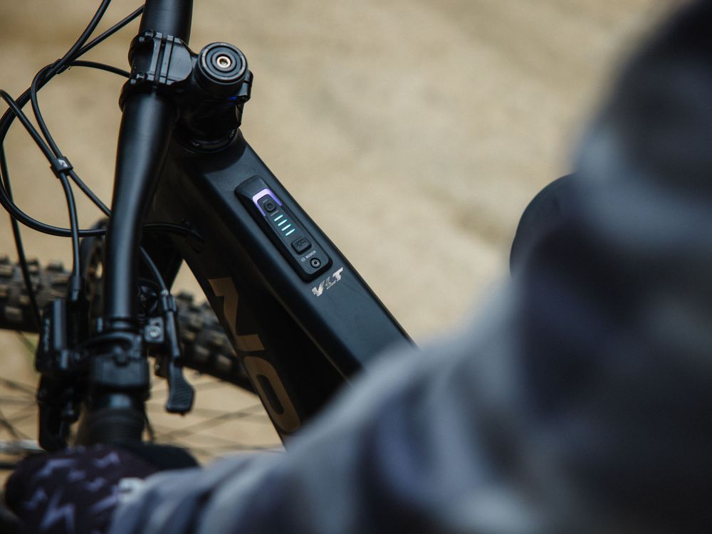Close-up of an e-bike battery display panel mounted on a dark bicycle frame.