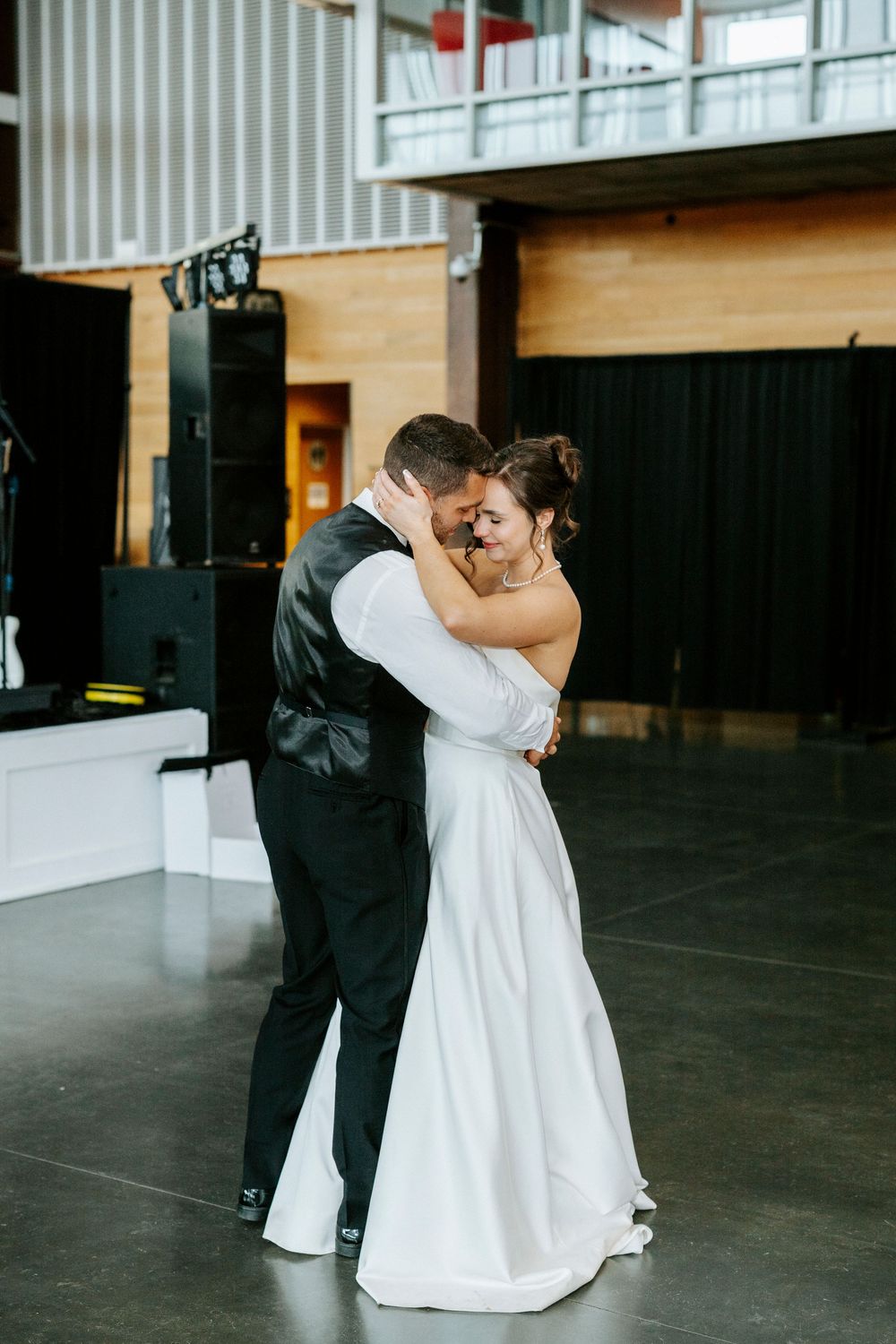 Bride and groom share an intimate first dance embrace on the dance floor at their wedding reception.