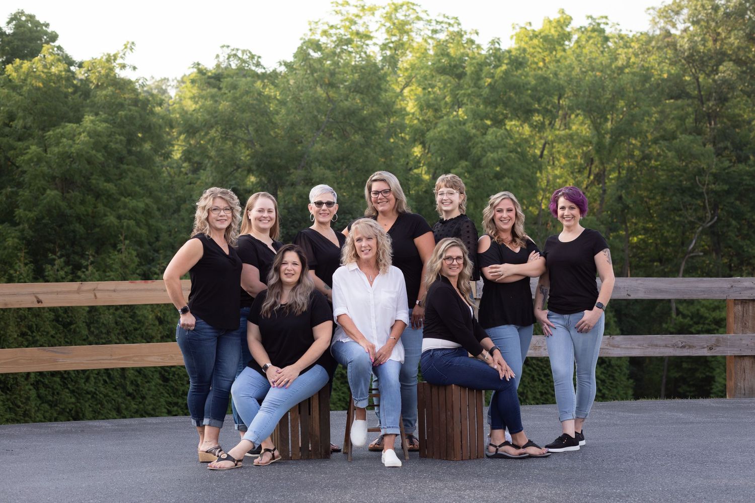Group of people sitting casually together on wooden benches in an outdoor setting during golden hour.