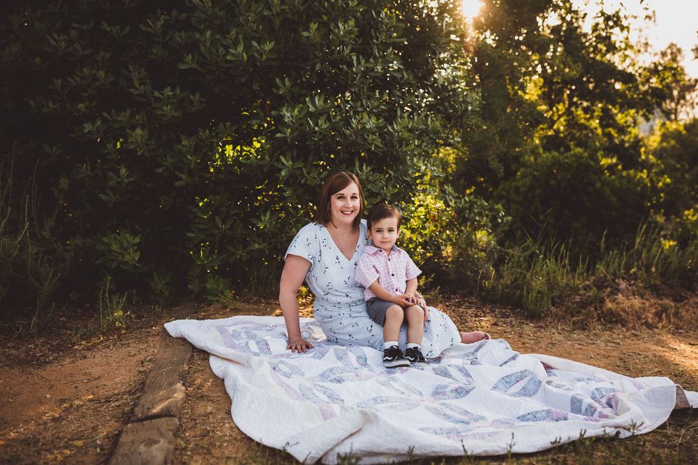 A sunset photoshoot in a natural outdoor setting with golden light filtering through trees.
