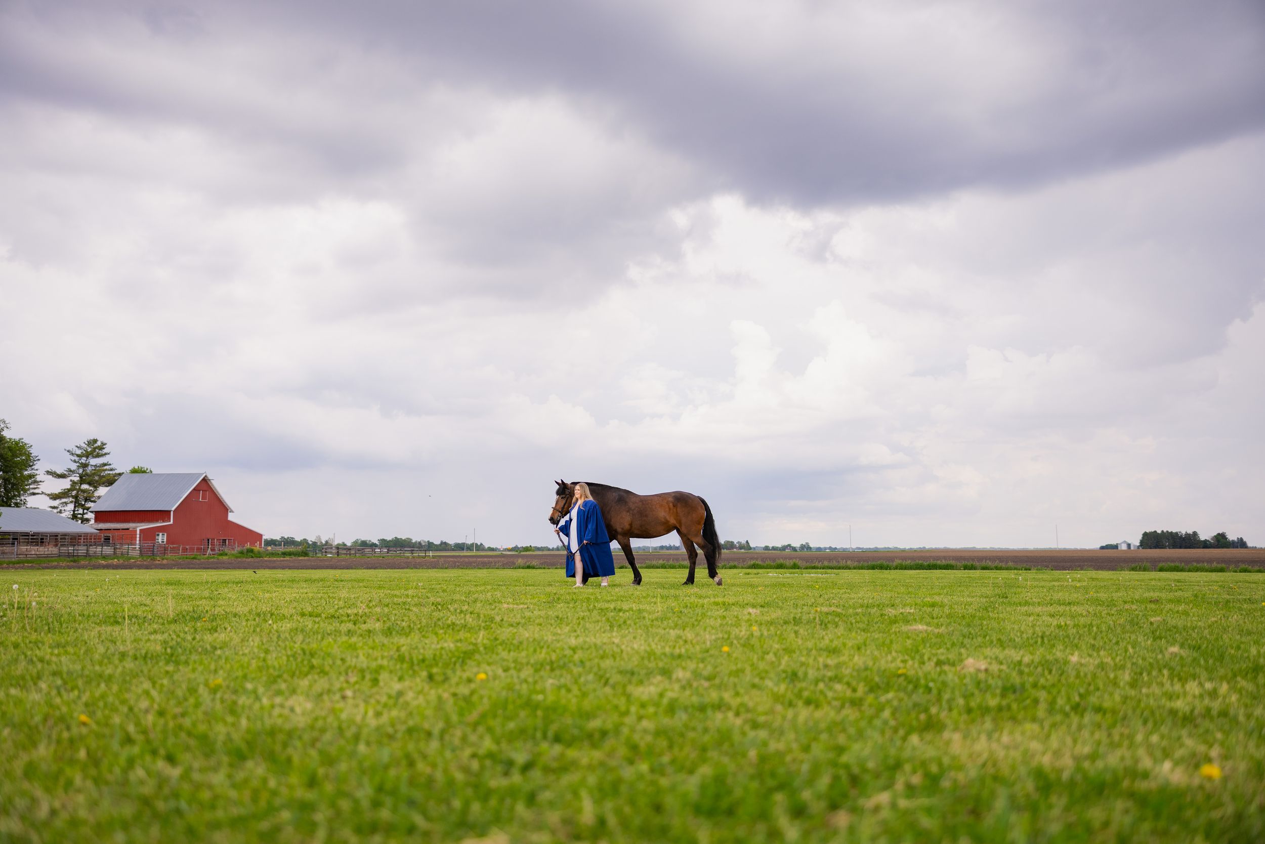 Graduating student walking in the field with her horse at UIUC