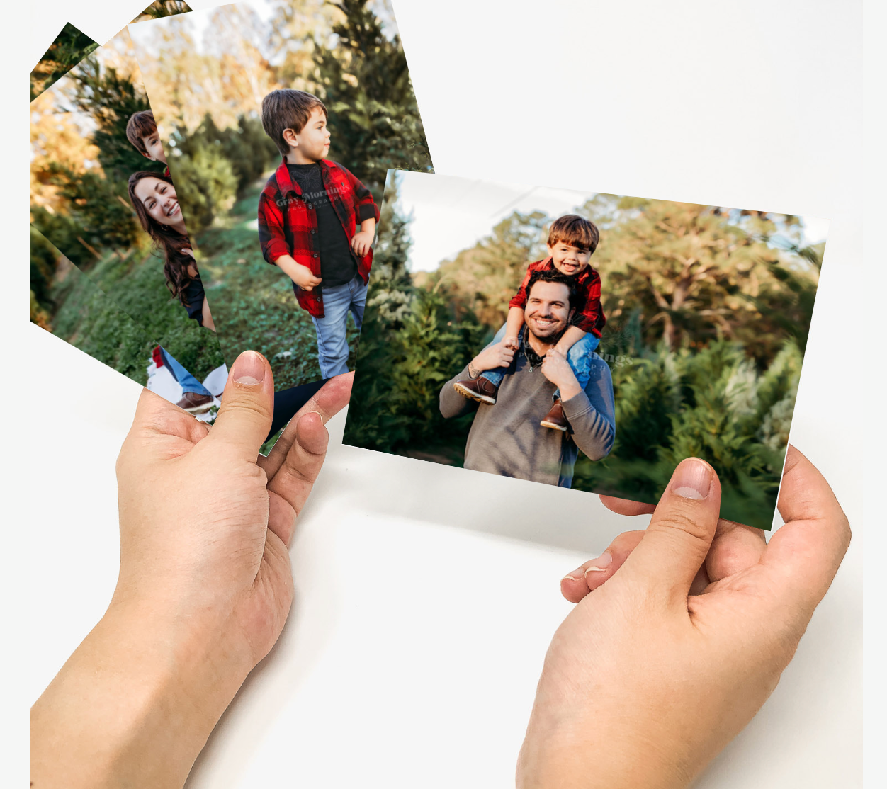 Hands holding a series of overlapping photographs showing people enjoying outdoor autumn activities in nature.