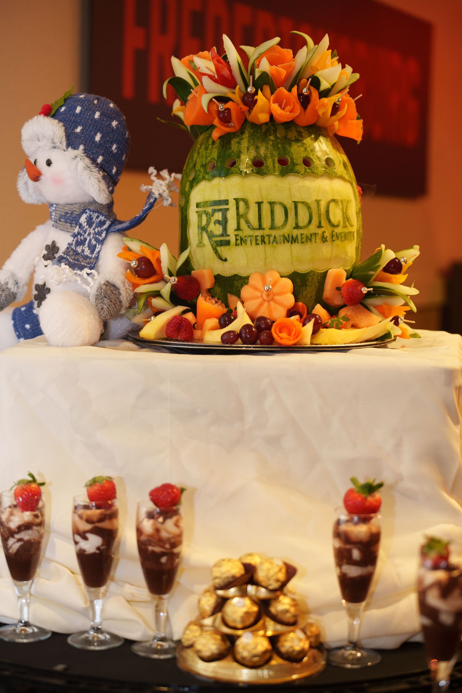 Dessert table with stuffed animals, floral arrangements, and chocolate mousse cups.