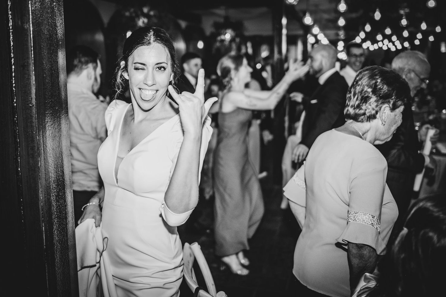 Novia haciendo gestos divertidos mientras celebra durante la entrada de los novios al banquete en una boda en Asturias, con otros invitad