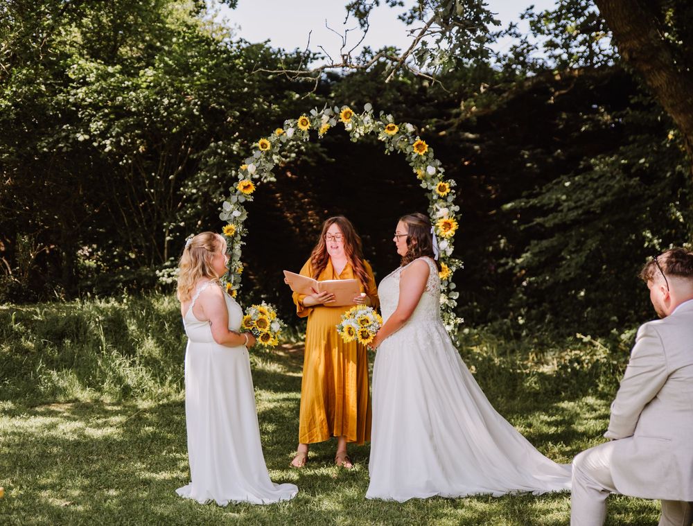 Gaggle of Geese Tipi outdoor wedding venue in Dorset. LGBTQ+ wedding photographer Dorset. Sunflower wedding bouquet and sunflower arch