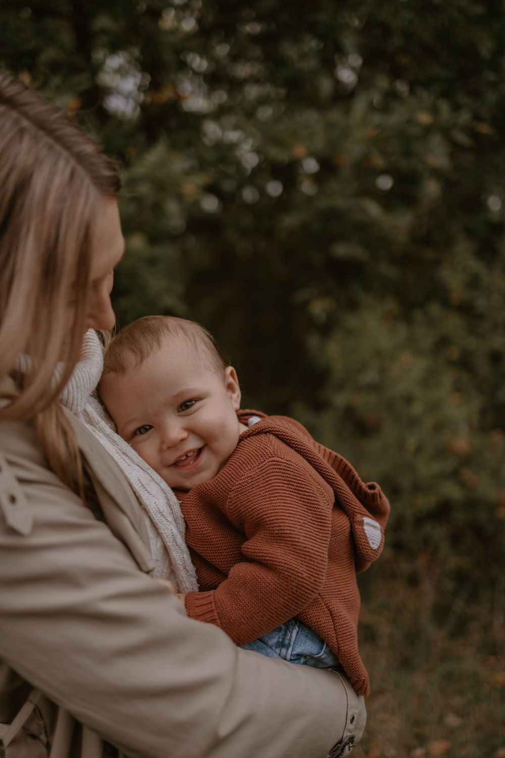 Intimate portrait of a Mum and baby in warm autumn tones with natural outdoor lighting.