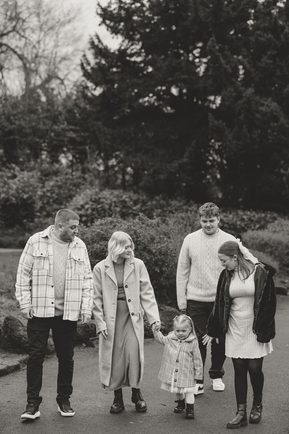 Family members walking together on a path through an autumn park.