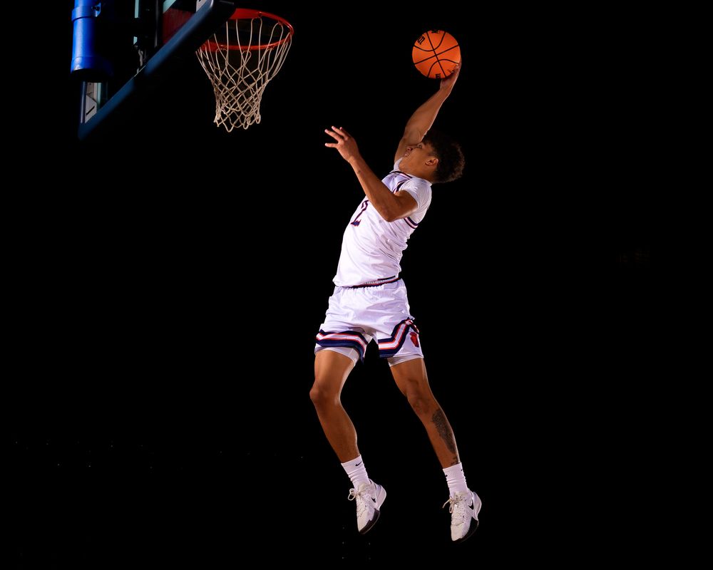 Hershey basketball senior in mid-air, reaching for a dunk with the hoop in view, captured during Media Day action session.