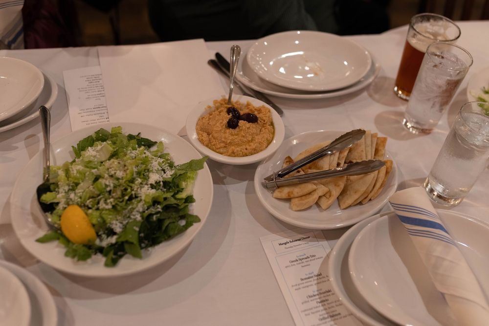 A series of restaurant dining photos showing various dishes including salads, appetizers and entrees served on white plates.