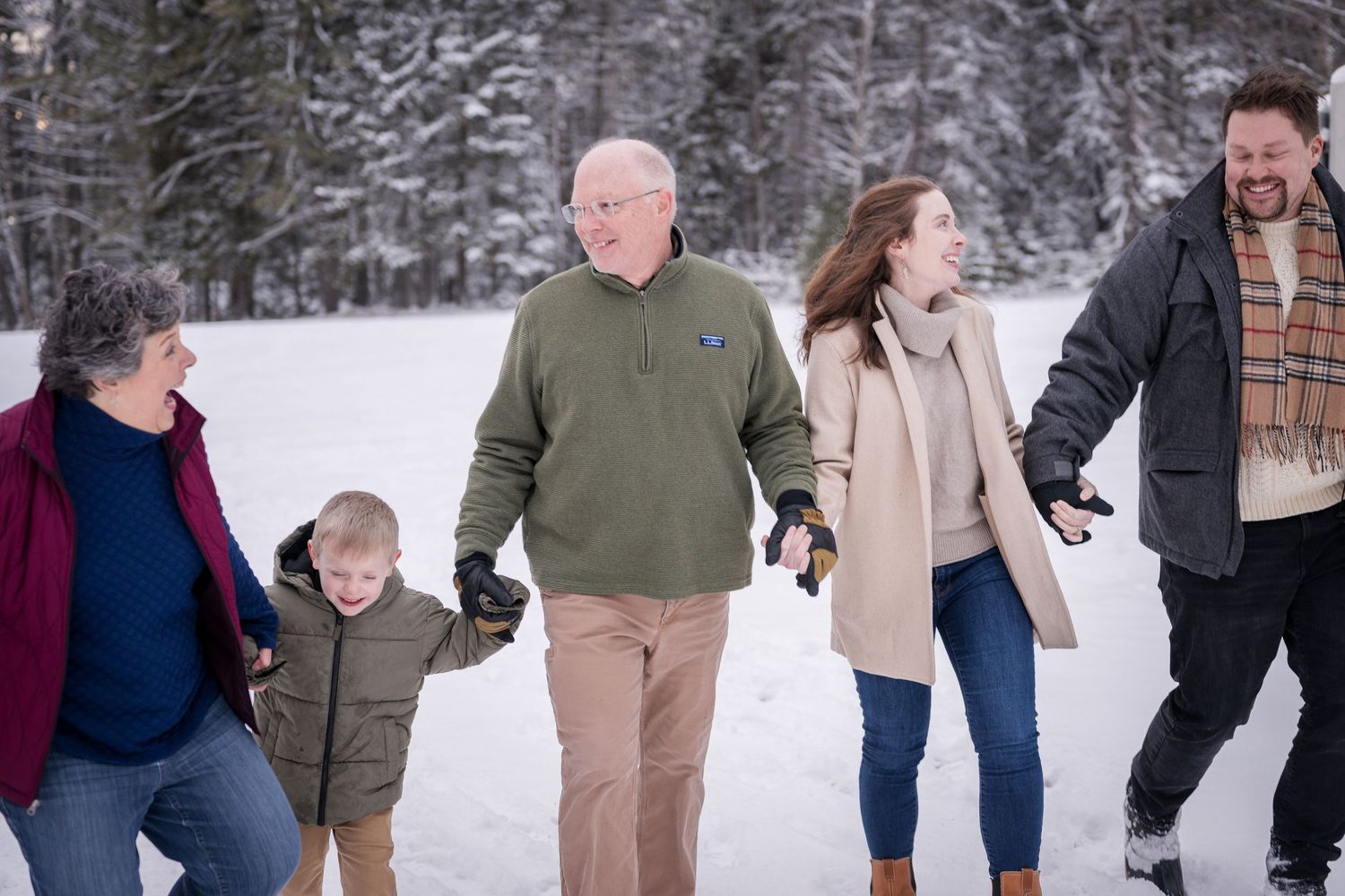Winter family photoshoot capturing natural moments of joy and connection in the snow.