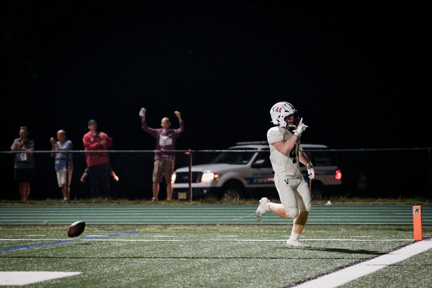 A sequence of football game action shots showing plays and tackles on a dark field at night.