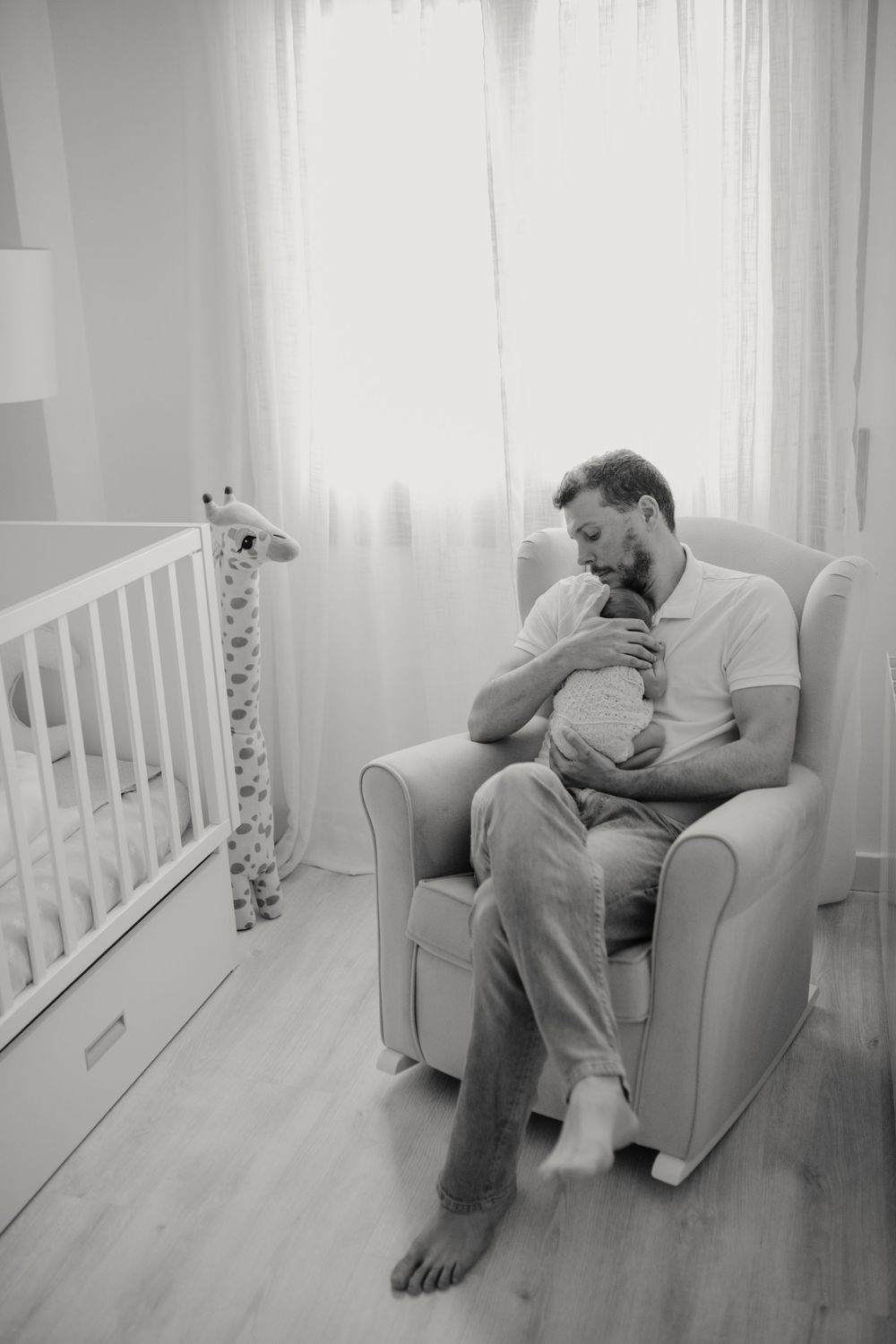 Padre abrazando a su bebé en sesión newborn lifestyle