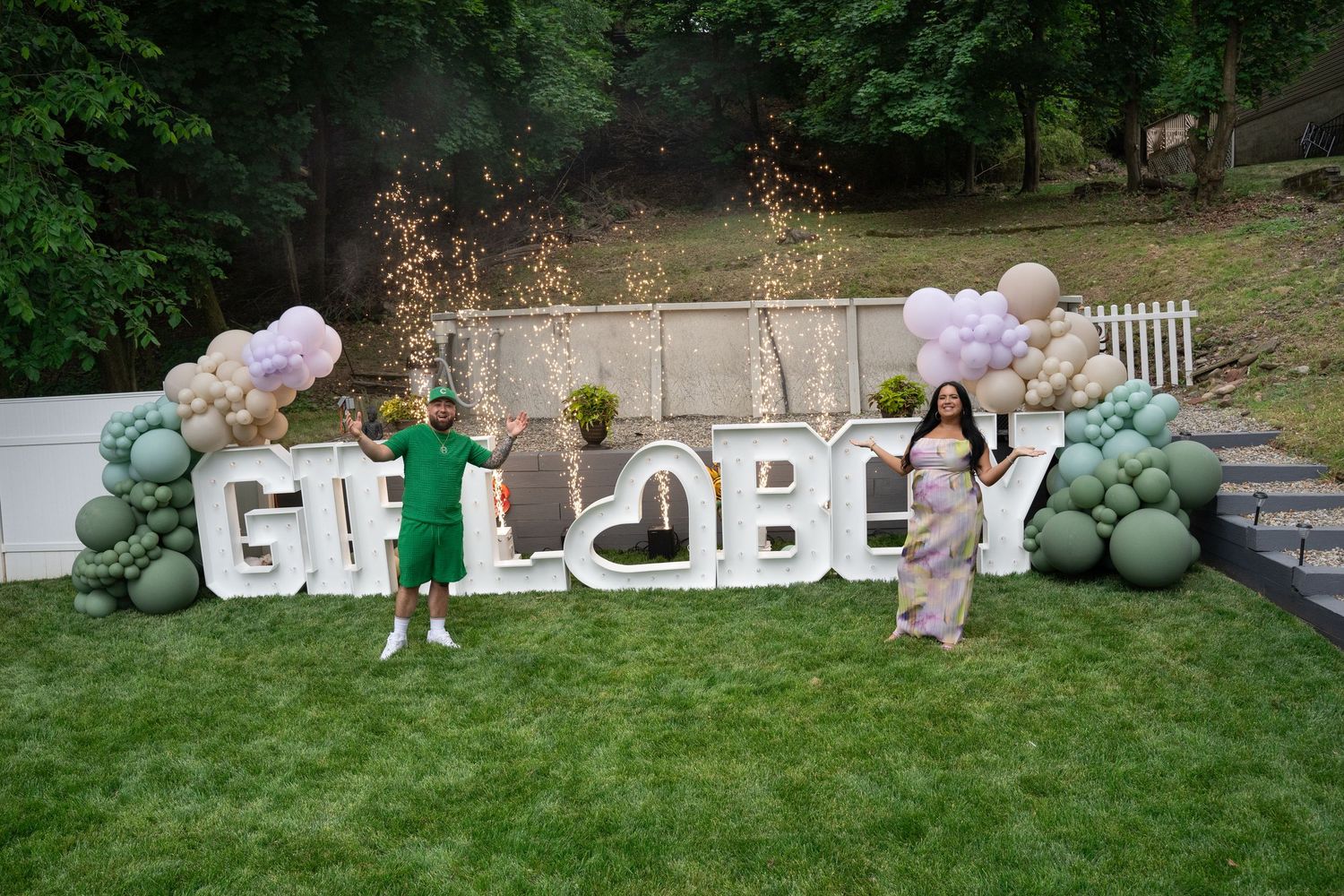 Outdoor wedding setup with large white balloon garlands and decorative letters spelling 'BRIDE' on a grassy lawn.