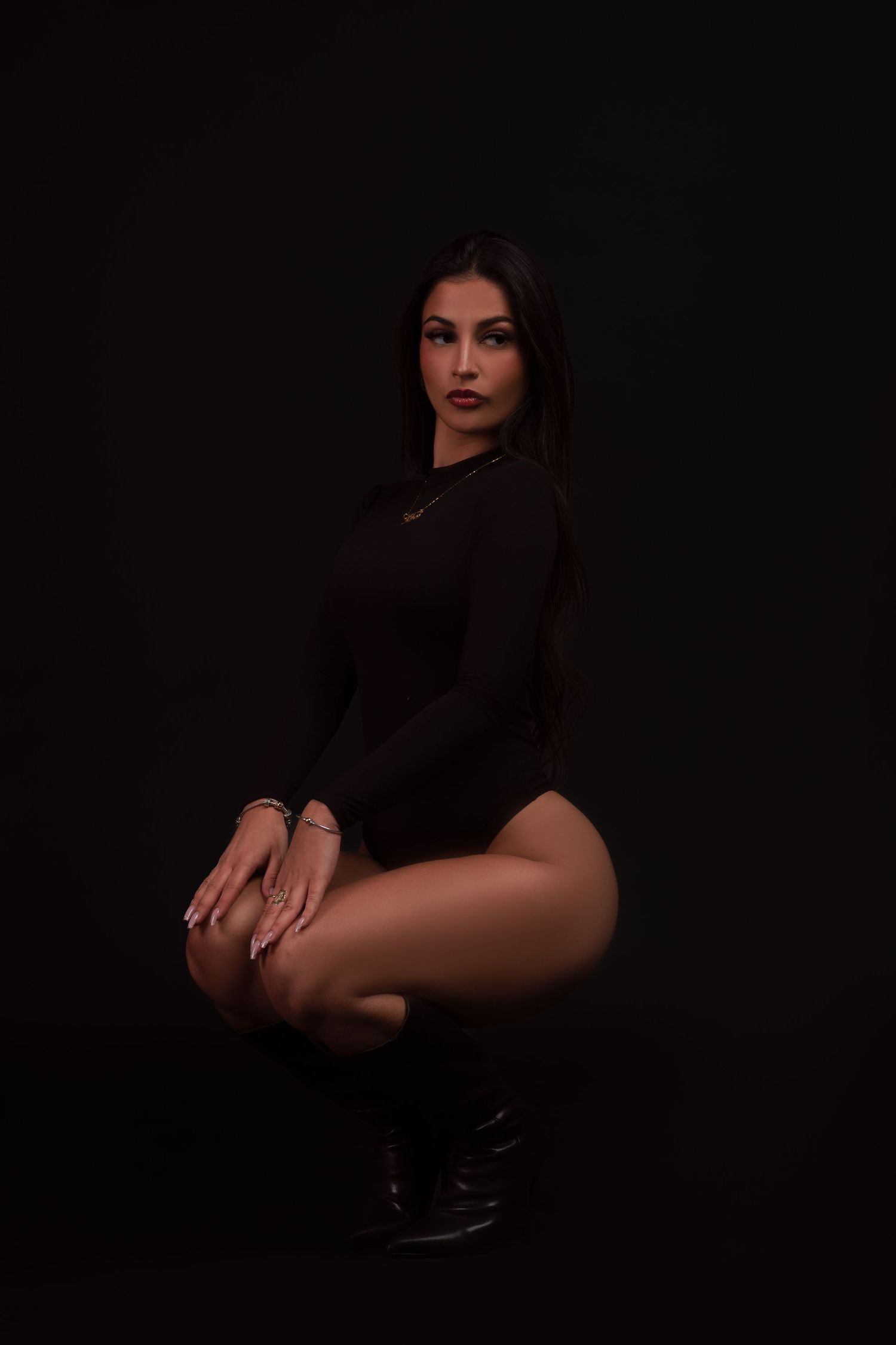 A dramatic black and white photo series showing a figure in dark clothing posing artistically against a dark background.