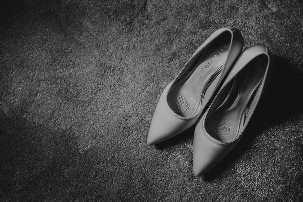 A sequence of black and white photographs showing high heeled shoes arranged in different positions on a textured surface.