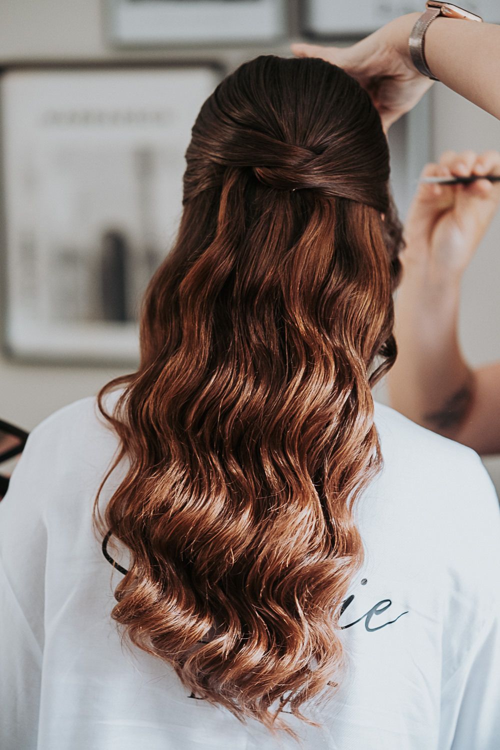 Close-up series showing styling process of wavy brown hair with soft curls being pinned and arranged.