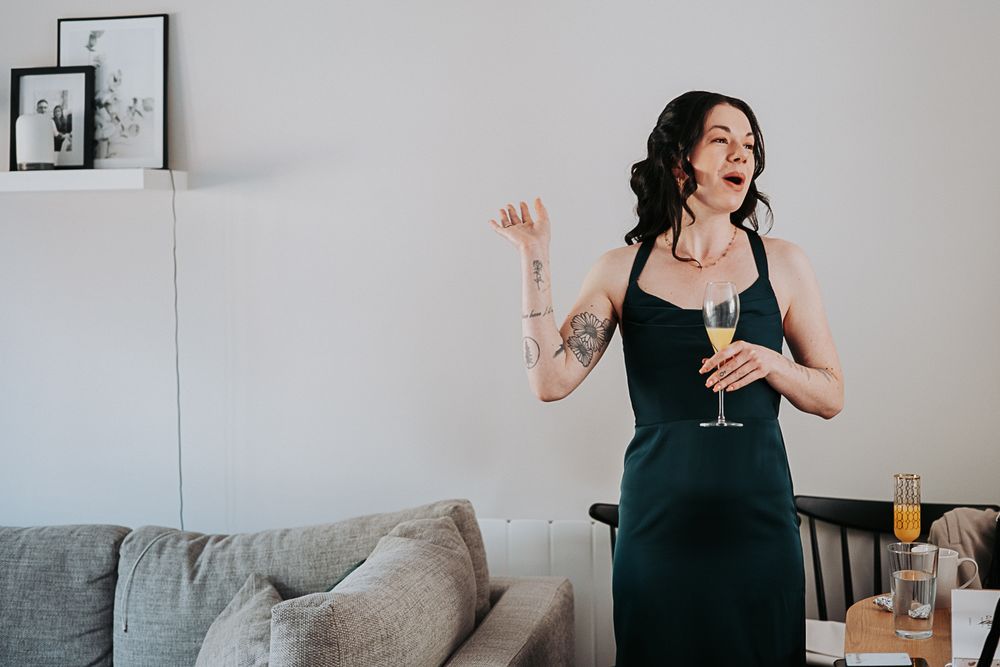 A sequence of candid moments showing someone in black attire against a light gray wall with framed artwork.