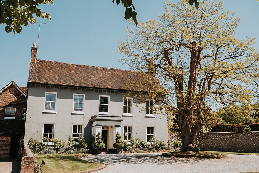A panoramic view of rustic farm buildings and cottages with brown roofs nestled among autumn trees.