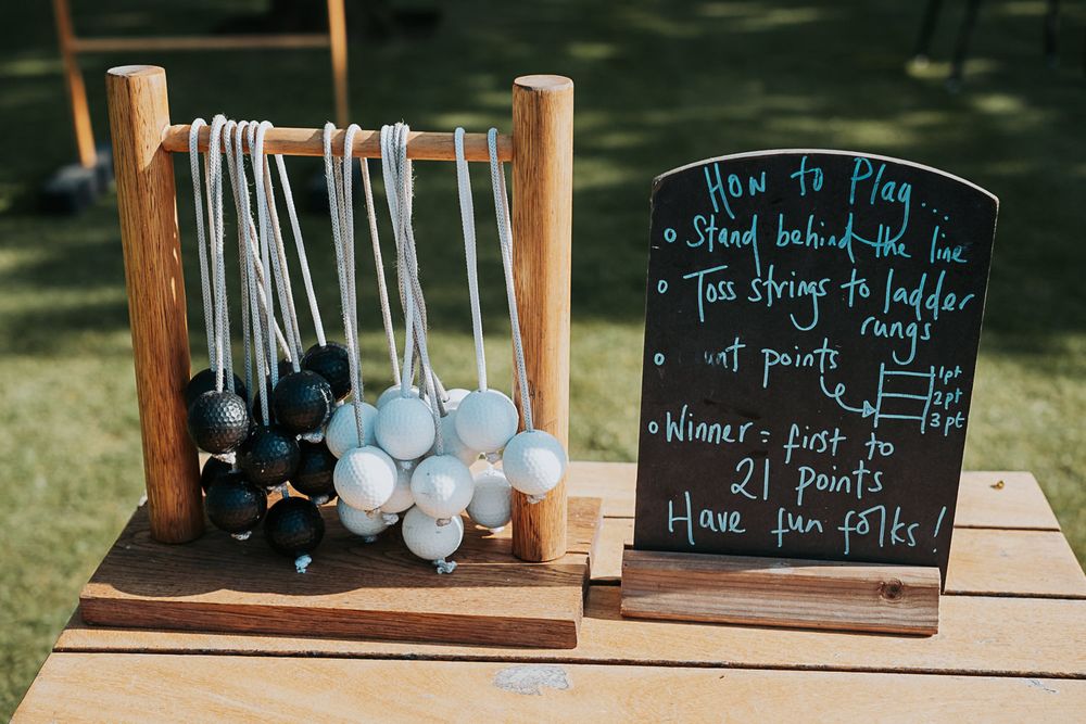Rustic wooden display shelf with chalkboard signs and hanging coffee mugs in an outdoor garden setting.