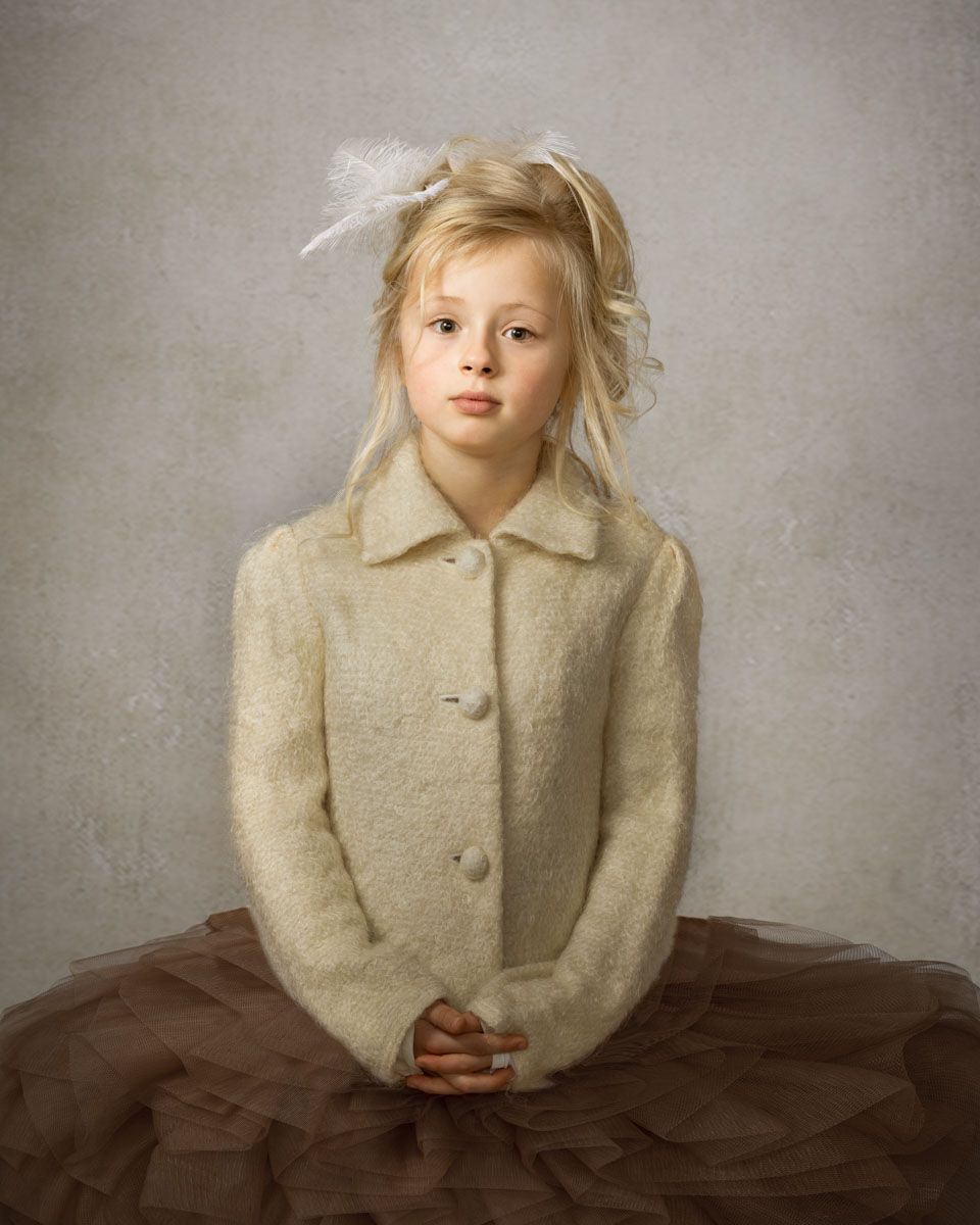 Striking fine art portrait of little girl, styled with lavish hairstyle