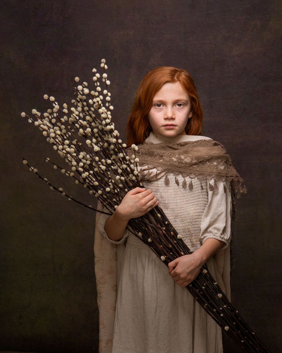 Striking fine art portrait of little girl, holding willow stems