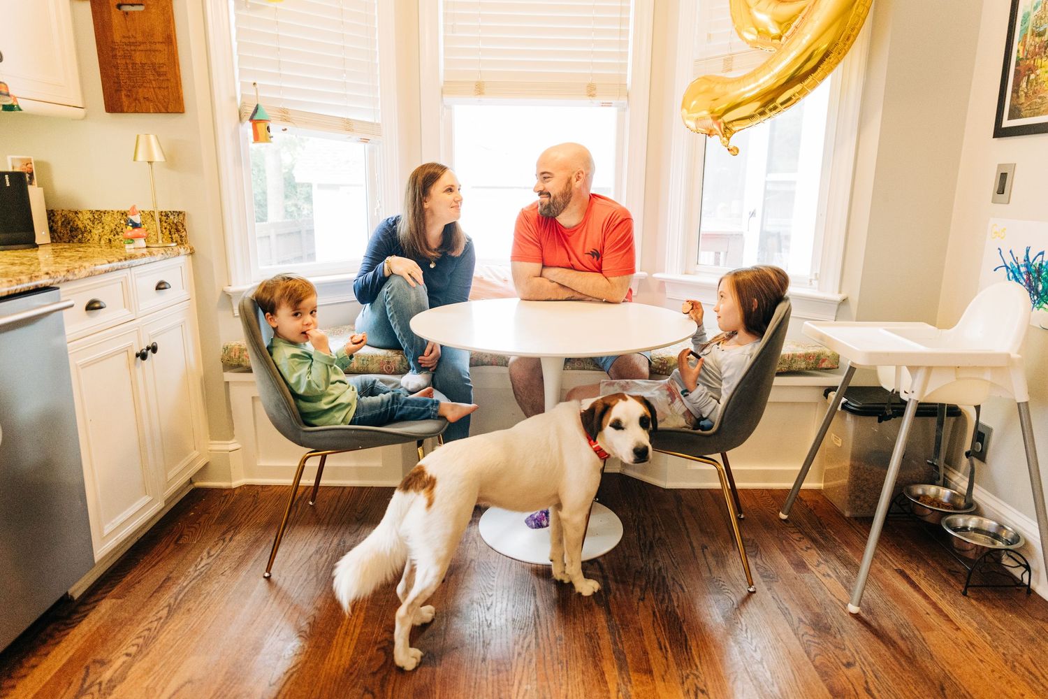 A family gathers around their dining table enjoying a meal together