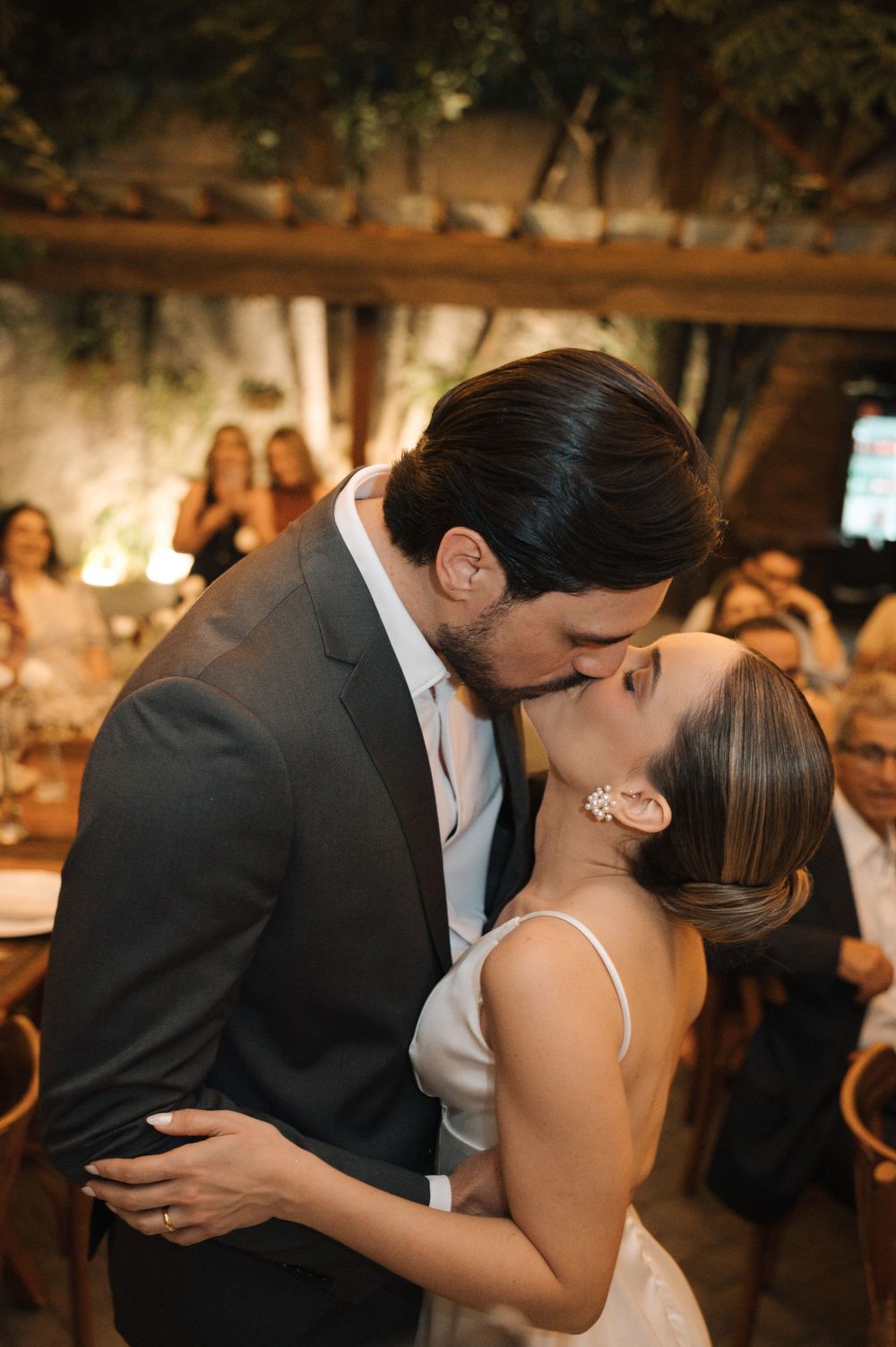 Romantic sequence of newlyweds sharing their first dance kiss at an intimate candlelit wedding reception.