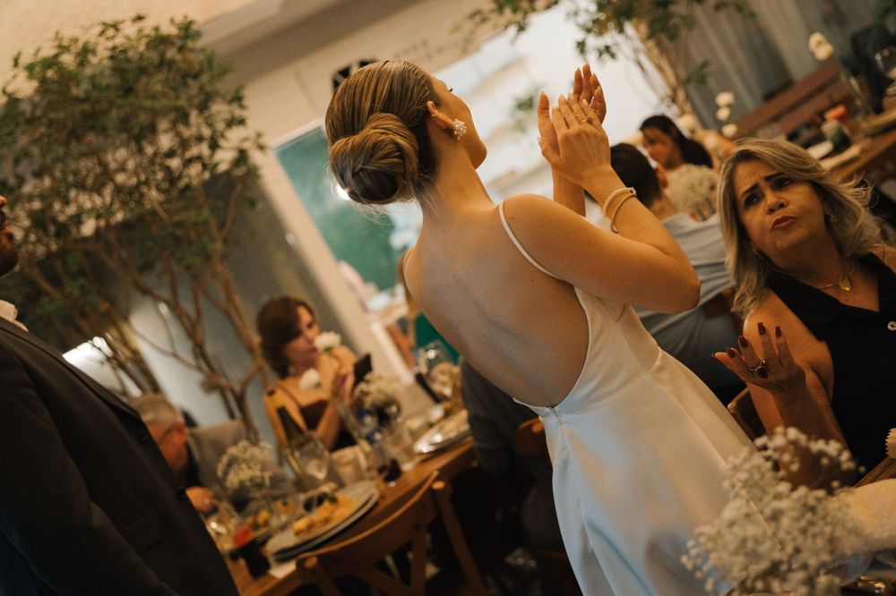 Wedding reception guests enjoying dinner at elegantly decorated tables with floral centerpieces and ambient lighting.