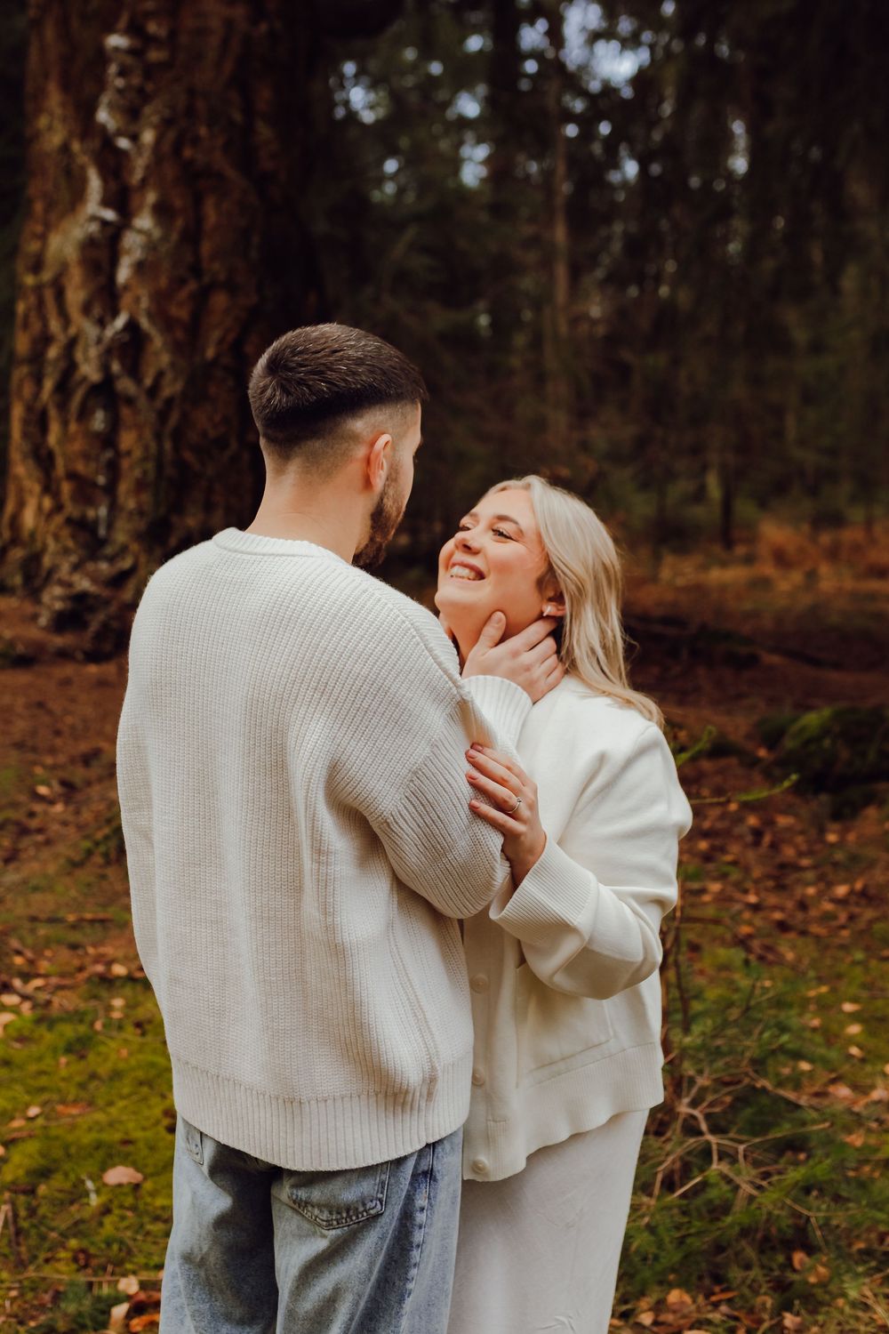 A couple laughing together during relaxed outdoor engagement shoot.