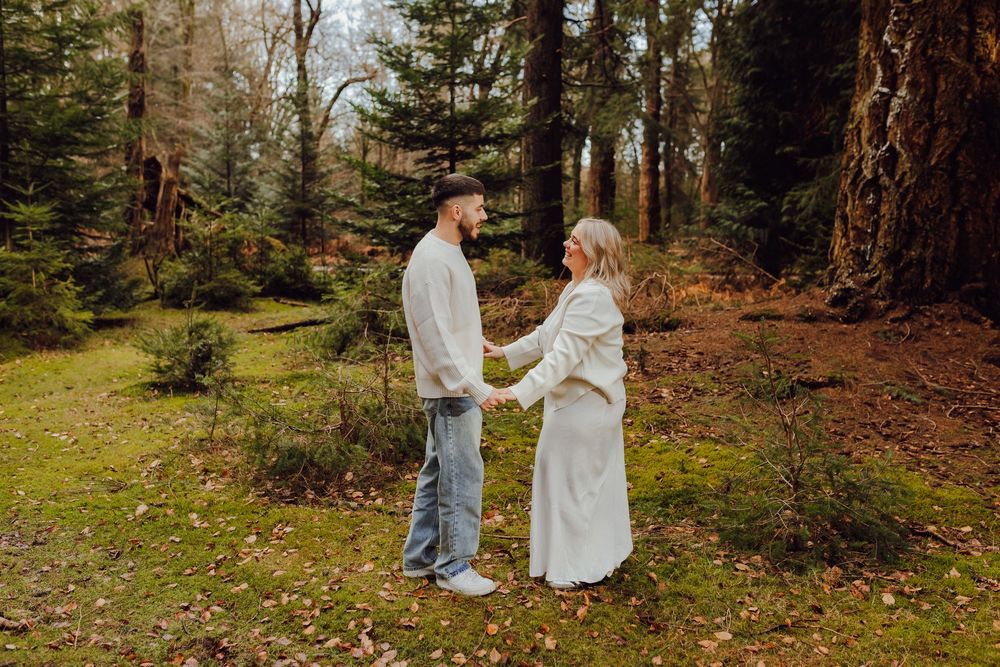 Romantic engagement portrait of Hannah and Jordan embracing outdoors.