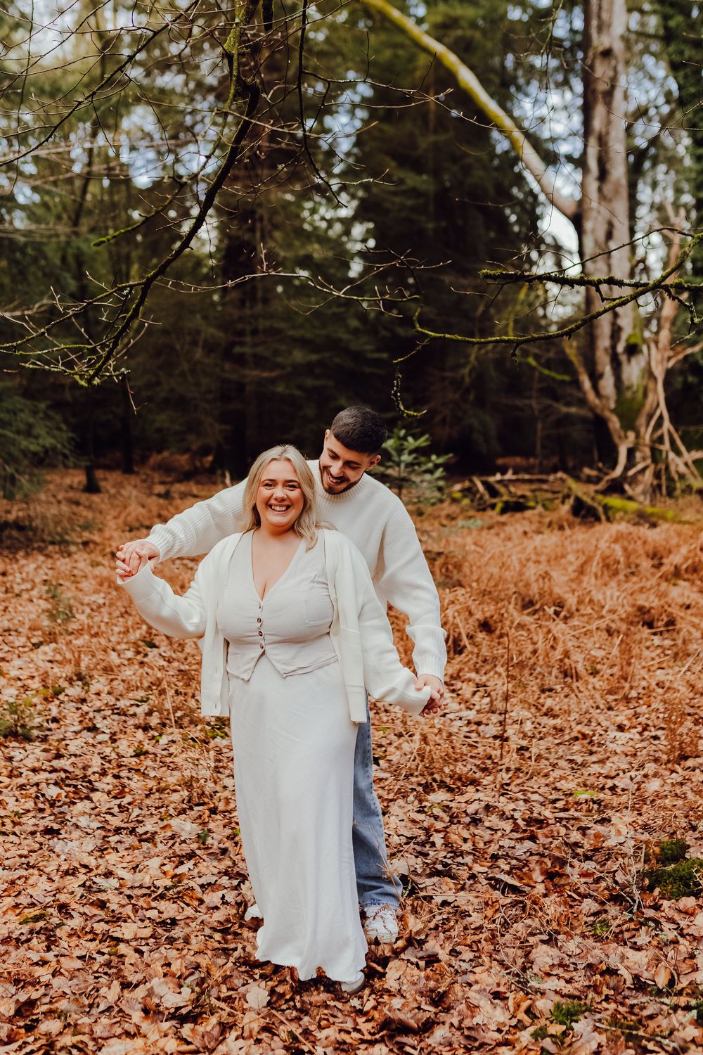 Hannah smiles while Jordan wraps his arms around her outdoors.