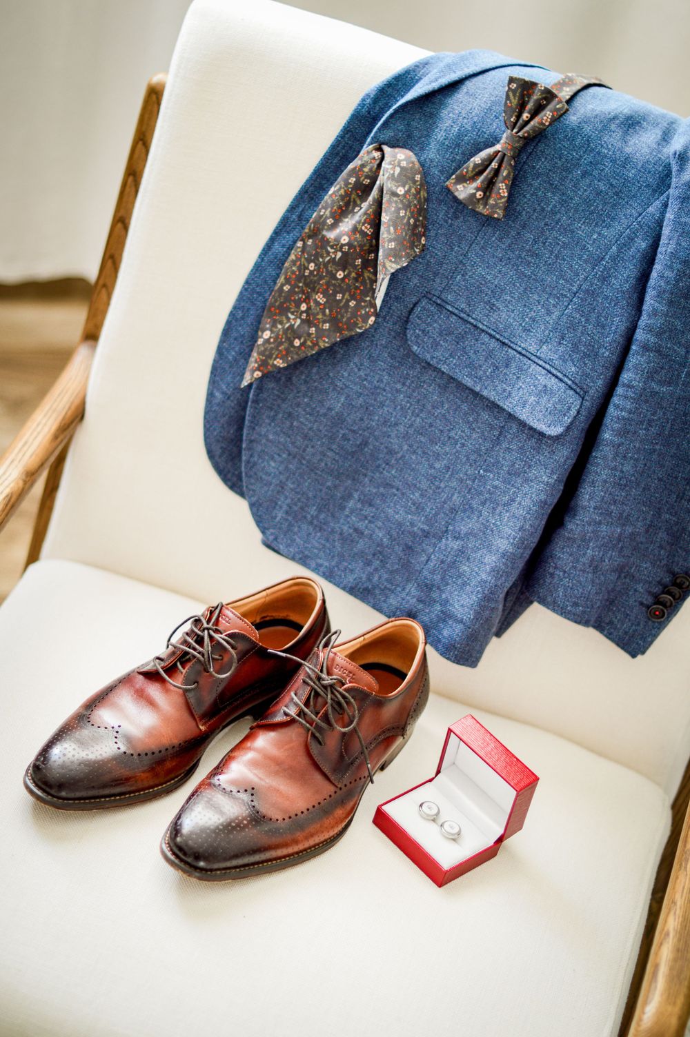 Flatlay Digel-Anzugschuhe, Manschettenknöpfe, Einstecktuch, Fliege und Sakko des Bräutigams.