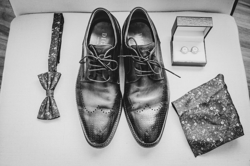 Flatlay der Digel-Anzugschuhe, Manschettenknöpfe, Einstecktuch und Fliege in bräunlichen und roten Herbsttönen.