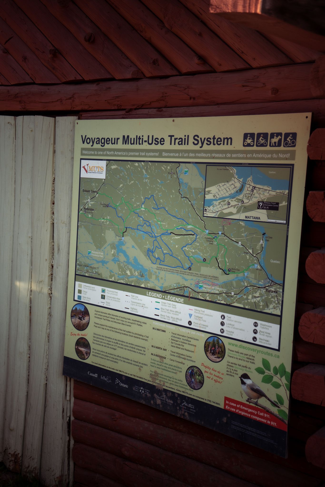 An informational trail map sign displaying the Voyageur Multi-Use Trail System with waterways and routes marked on a wall.