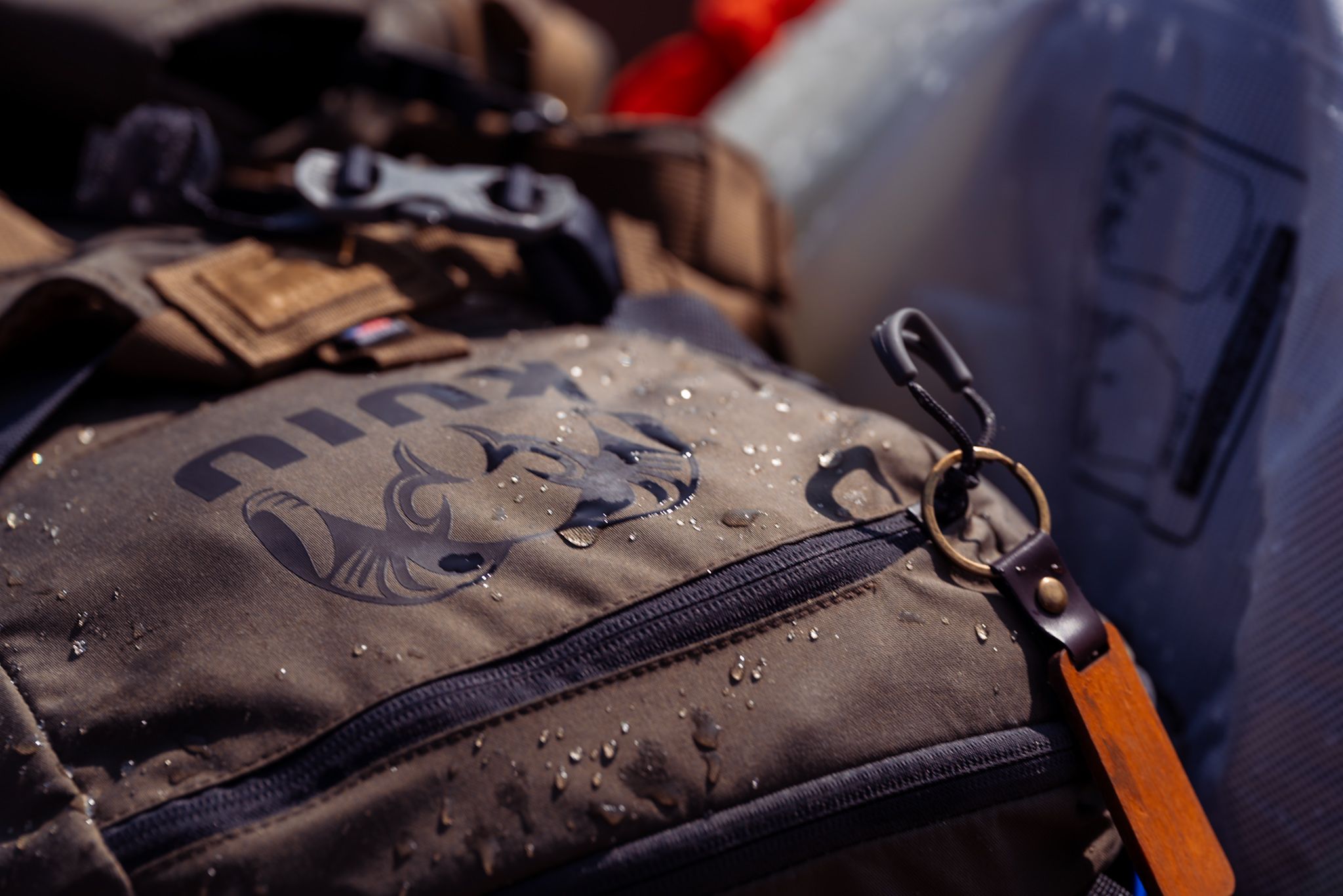 A wet grey backpack with water droplets showing its water-resistant properties in a close-up shot.