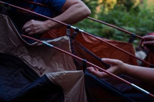 Close-up view of hands playing string instruments in a duet performance at sunset.