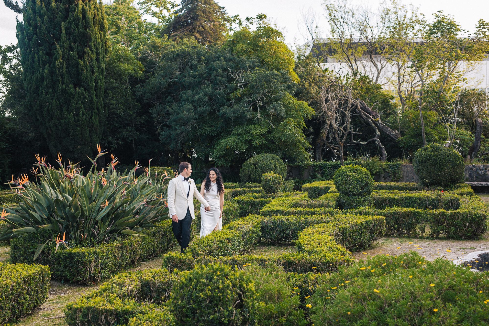 Bride & groom walking in a french garden at quinta do Torneiro, Lisboa. Captured by a Portugal destination wedding photographer.
