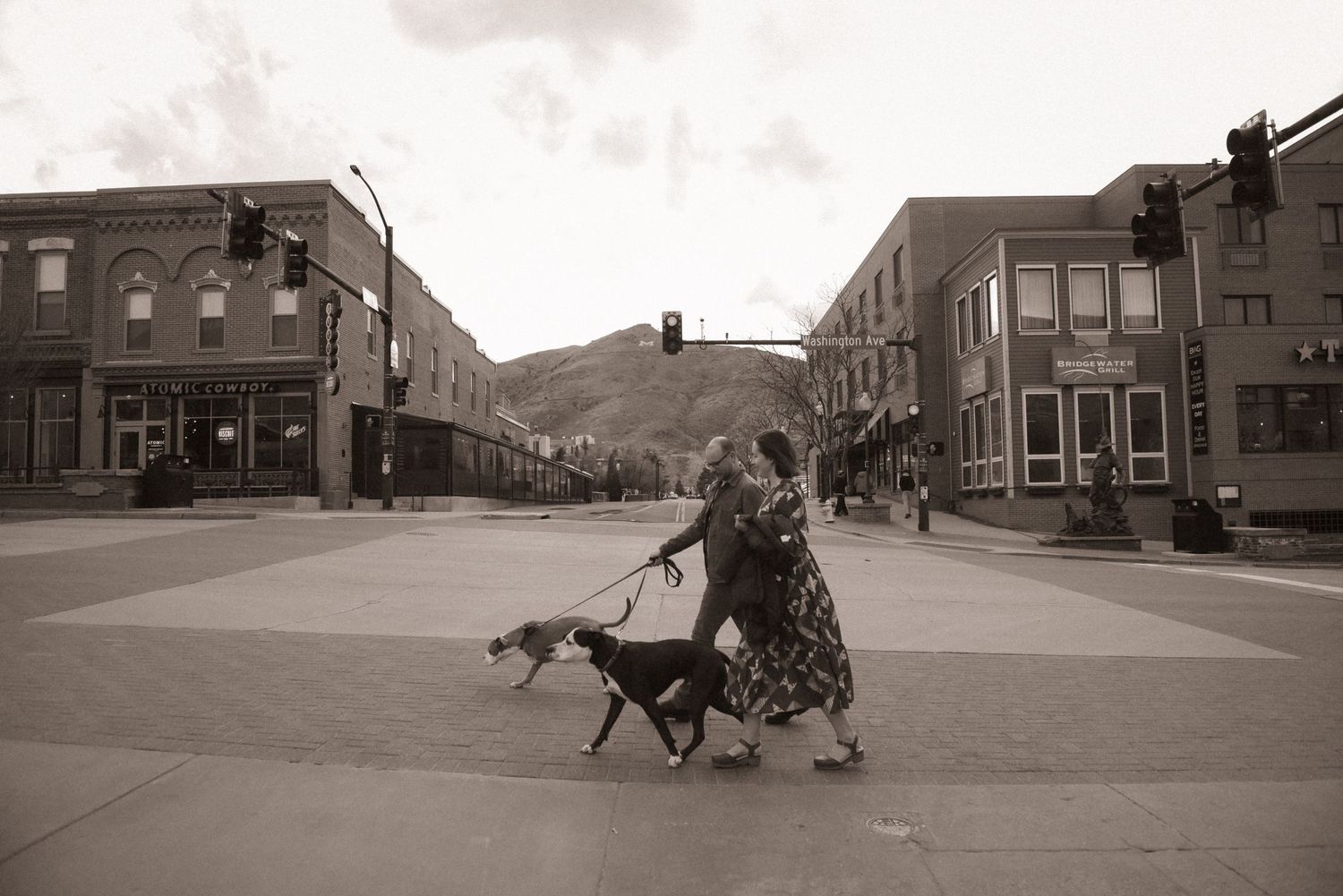 A panoramic sequence of sepia-toned vintage urban street photographs showing city buildings and daily life from the early 1900s.