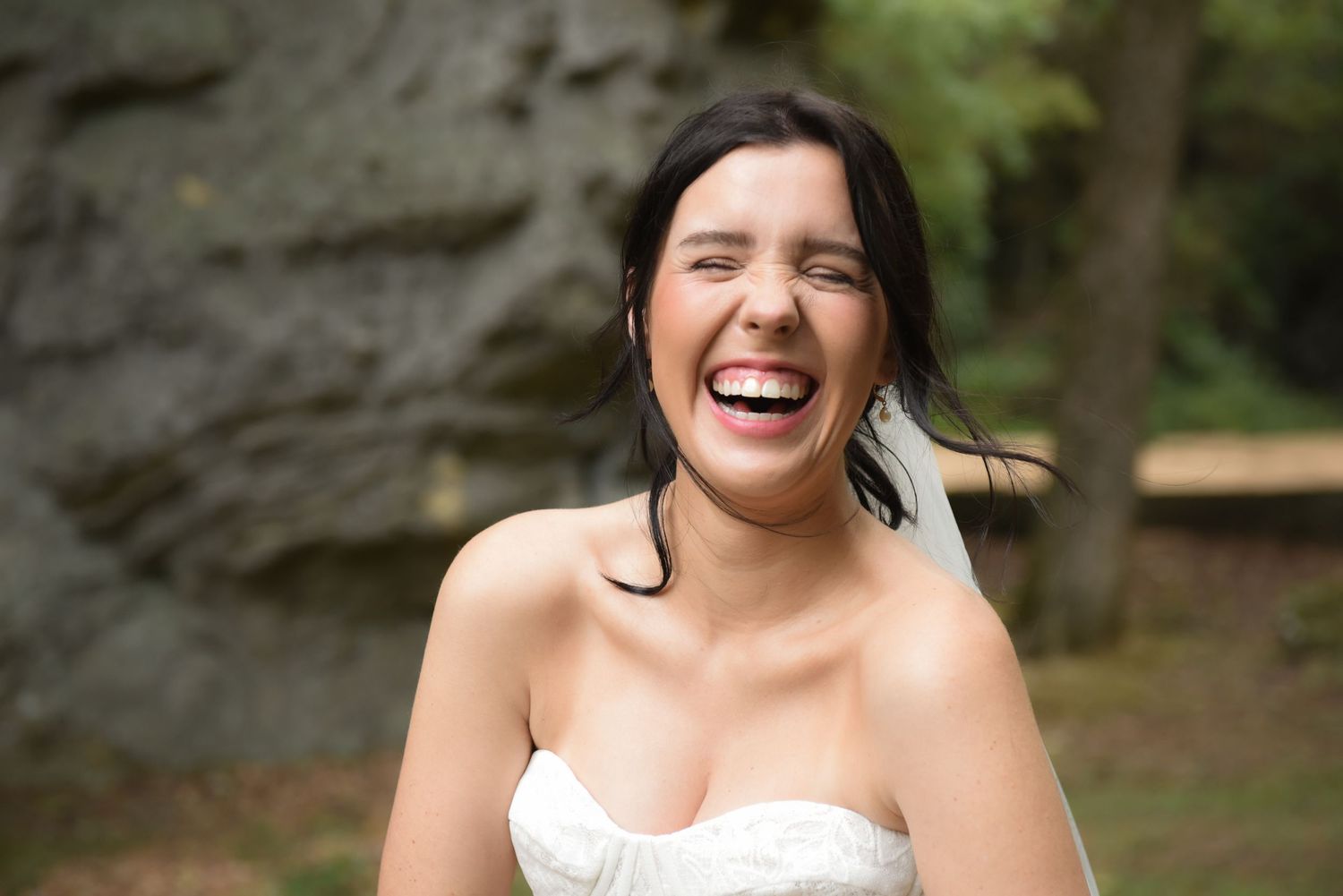 A series of laughing and joyful expressions captured in a wedding photoshoot sequence against a natural outdoor background.