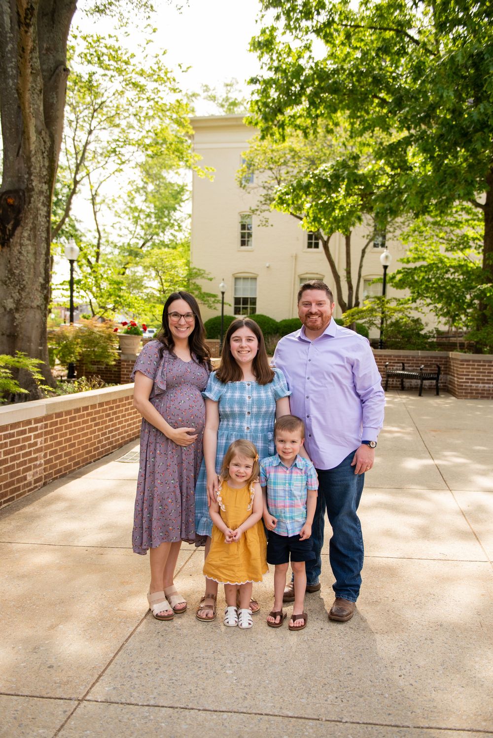 Family portrait session showing progression of poses outdoors near a brick building.