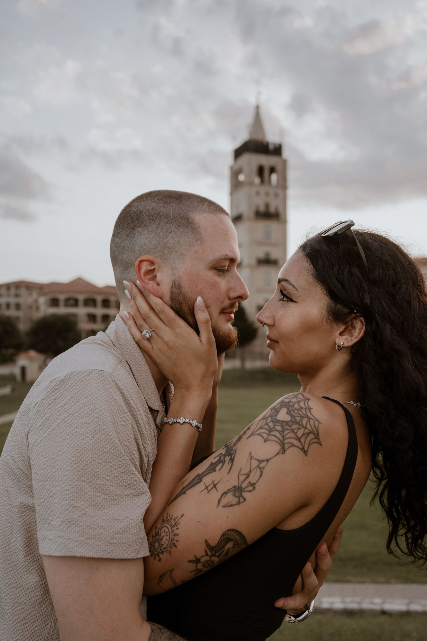 Intimate portrait session with architecture visible in the cloudy background.