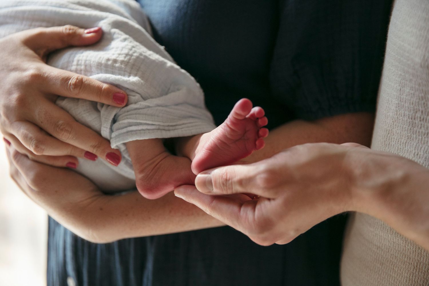 Close-up of hands tenderly touching in soft window light.