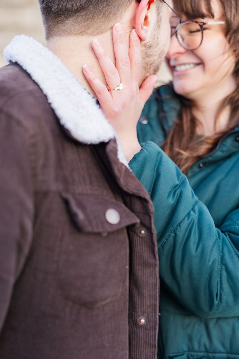 Close-up of an affectionate moment showing an engagement ring.