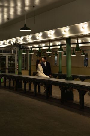 Romantic nighttime scene in vintage subway station with pendant lights and green columns.