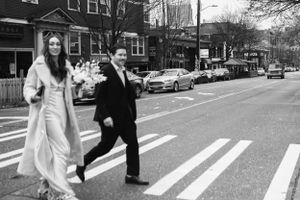 Couple crossing city street in formal attire on winter day.