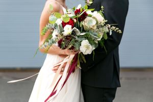 Close up of wedding bouquet with white roses and trailing ribbons.