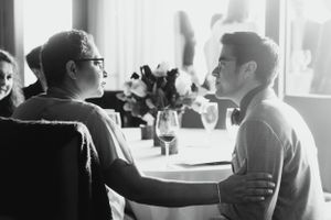 Couple having an intimate conversation at a table with wine glasses.